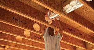 man-on-construction-site-cut-holes-in-joists
